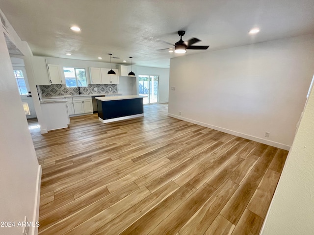 unfurnished living room featuring ceiling fan, light wood-type flooring, and sink