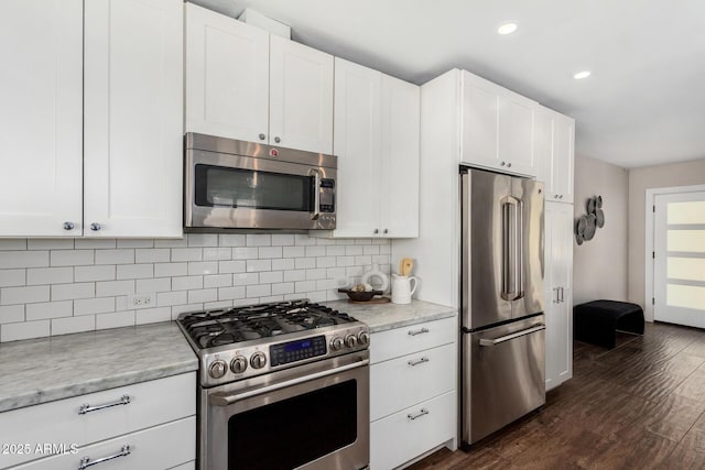 kitchen with white cabinets, tasteful backsplash, appliances with stainless steel finishes, and dark wood-style floors