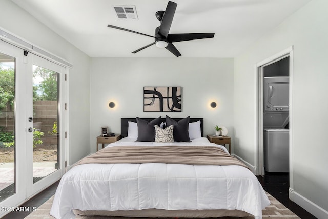 bedroom with wood finished floors, stacked washing maching and dryer, baseboards, access to outside, and visible vents
