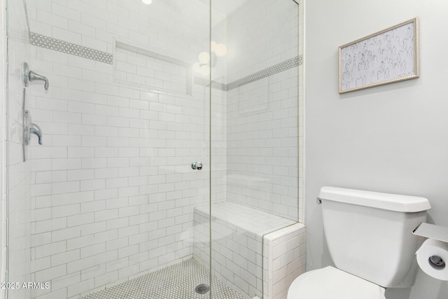 full bath featuring a stall shower and toilet