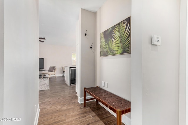 corridor with wood finished floors and baseboards