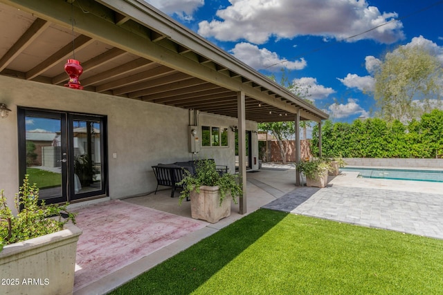 view of patio featuring fence, a fenced in pool, and french doors