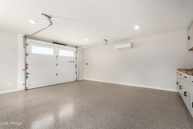 garage with recessed lighting, baseboards, and a wall unit AC