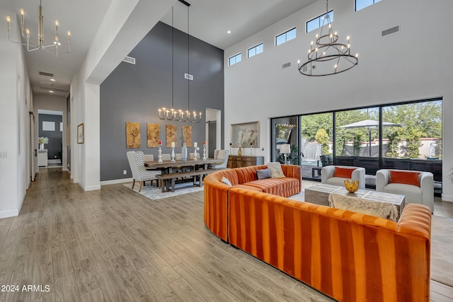 living room featuring a healthy amount of sunlight, a chandelier, and light hardwood / wood-style flooring