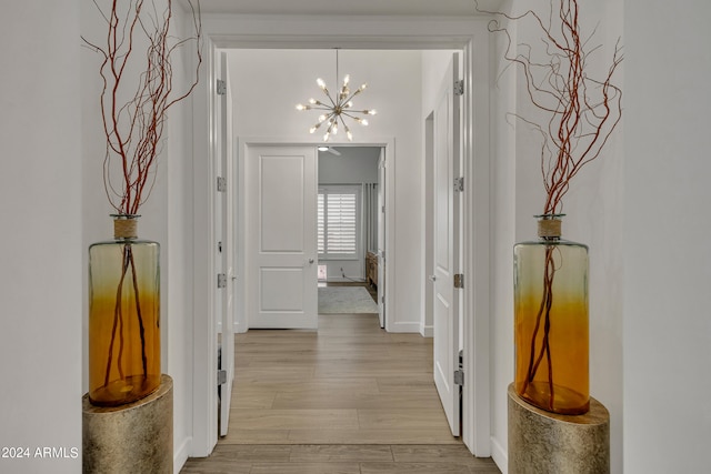 hallway with a chandelier and light hardwood / wood-style flooring