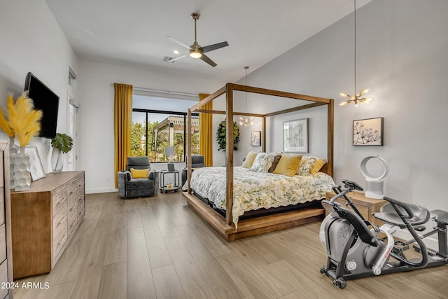 bedroom with ceiling fan with notable chandelier and light hardwood / wood-style flooring