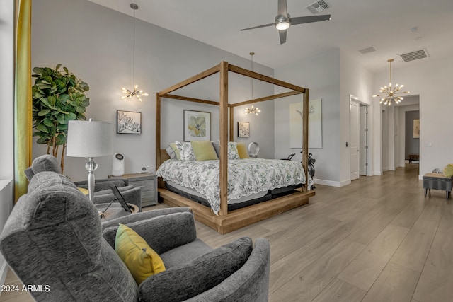 bedroom with an inviting chandelier and light hardwood / wood-style floors