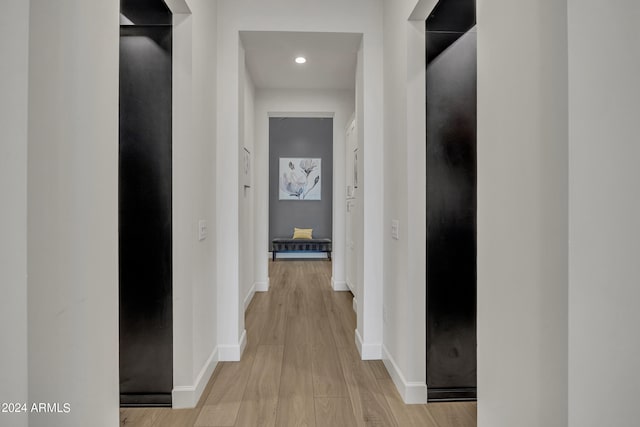 hallway with light hardwood / wood-style floors