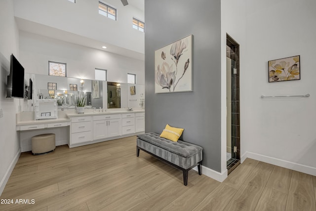 bathroom featuring vanity, wood-type flooring, and a high ceiling