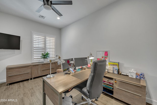 home office with light hardwood / wood-style floors and ceiling fan