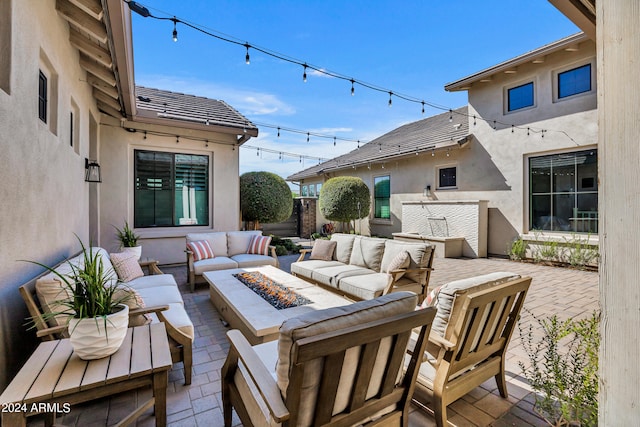 view of patio with an outdoor living space with a fire pit