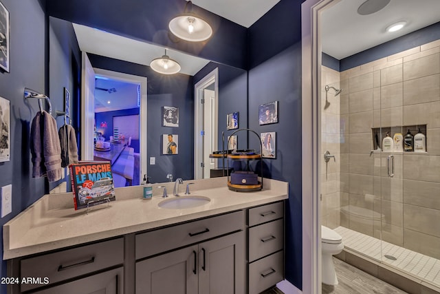 bathroom with an enclosed shower, vanity, and toilet