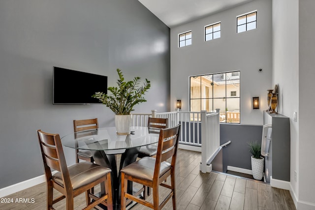 dining area with hardwood / wood-style flooring and a high ceiling