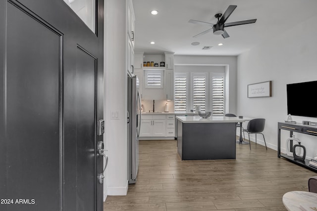 interior space featuring white cabinetry, sink, dark hardwood / wood-style flooring, a center island, and ceiling fan