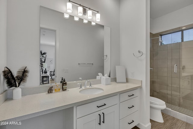 bathroom with vanity, toilet, a shower with door, and hardwood / wood-style floors