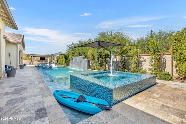 view of swimming pool featuring pool water feature and a patio area