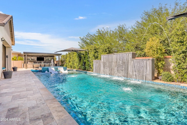 view of pool with pool water feature, a hot tub, and a patio area