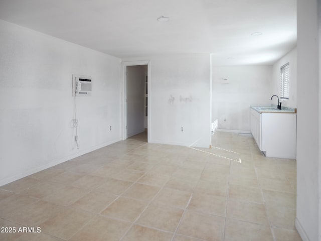 spare room featuring sink, light tile patterned floors, and a wall unit AC