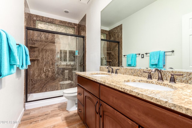 bathroom featuring wood-type flooring, vanity, toilet, and an enclosed shower