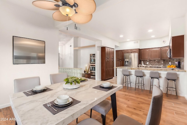 dining area with light hardwood / wood-style flooring and ceiling fan