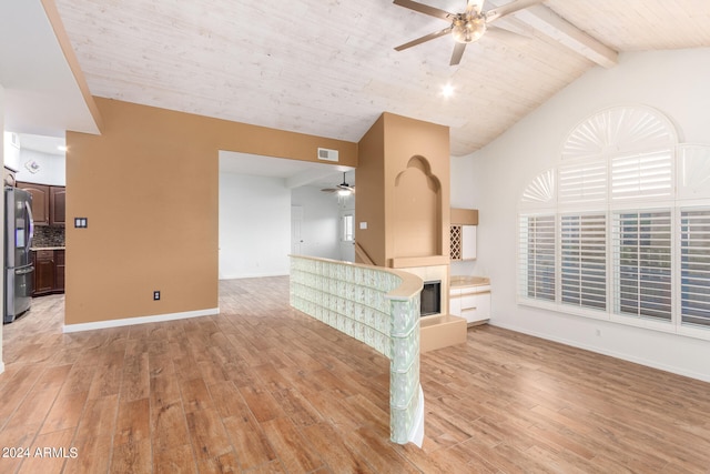 unfurnished living room featuring vaulted ceiling with beams, light wood-type flooring, and ceiling fan