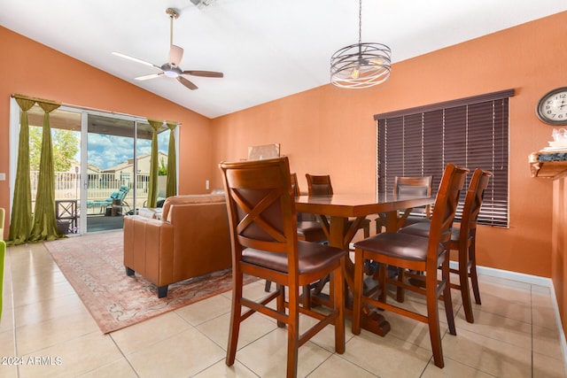 dining space featuring ceiling fan with notable chandelier, light tile patterned floors, and lofted ceiling