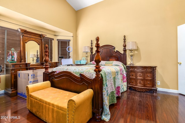 bedroom featuring dark wood-type flooring and high vaulted ceiling