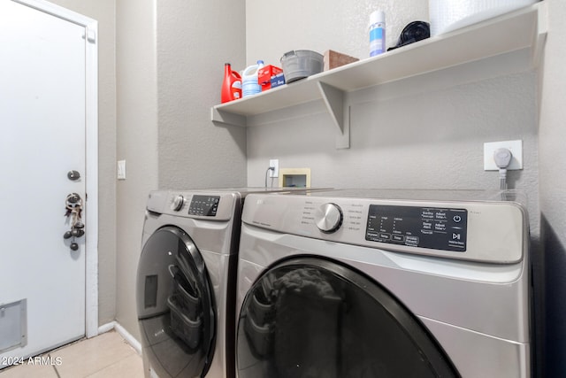 clothes washing area with light tile patterned flooring and independent washer and dryer