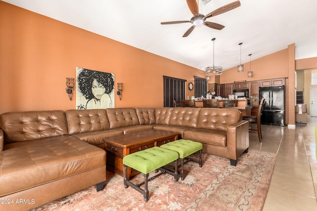 tiled living room with ceiling fan and high vaulted ceiling