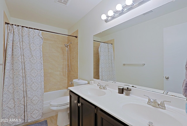 bathroom with visible vents, a sink, toilet, and double vanity