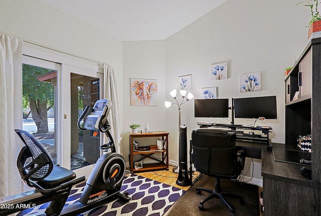 office with a textured ceiling, baseboards, and wood finished floors