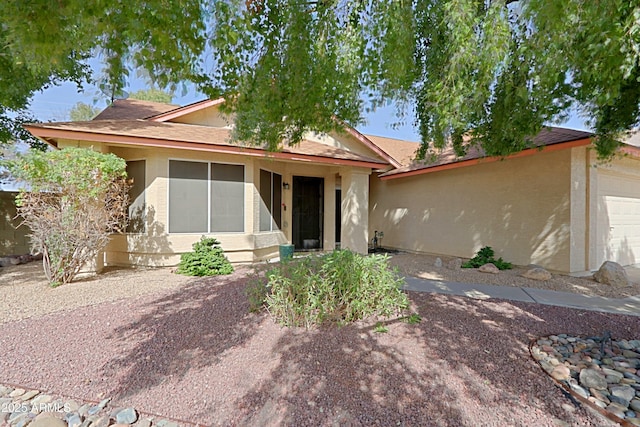 ranch-style home featuring an attached garage and stucco siding