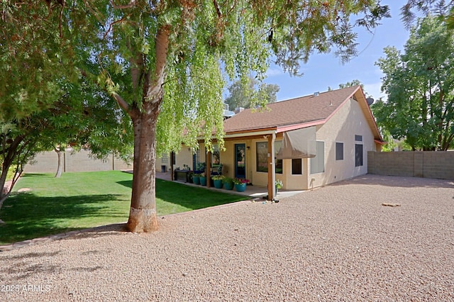 back of house featuring a patio area, fence, a lawn, and stucco siding