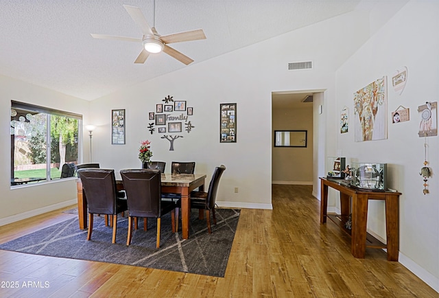 dining area featuring lofted ceiling, wood finished floors, visible vents, and baseboards