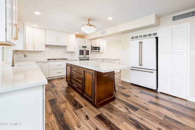 kitchen featuring white cabinets, a kitchen island, dark hardwood / wood-style flooring, stainless steel appliances, and sink