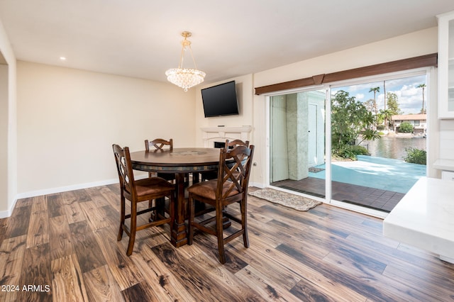 dining area with hardwood / wood-style floors and a notable chandelier