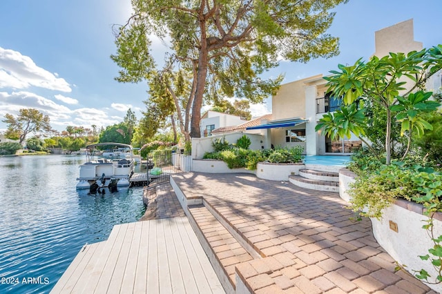 view of dock featuring a patio and a water view