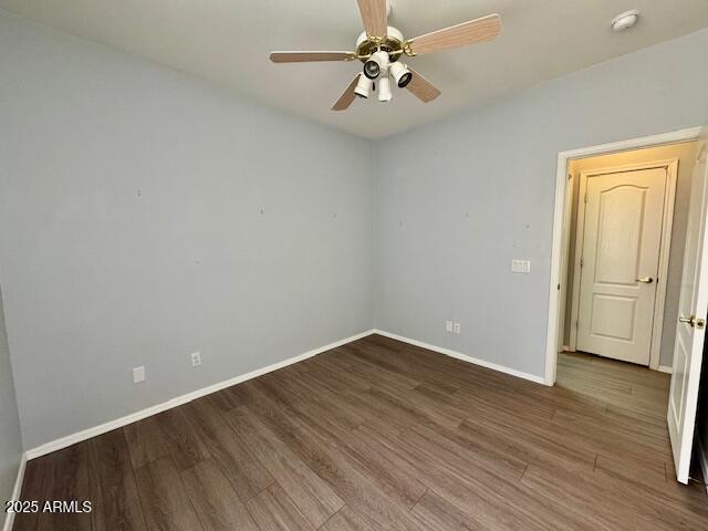 unfurnished room with ceiling fan, baseboards, and wood finished floors