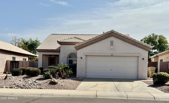 view of front of home featuring an attached garage, fence, and stucco siding