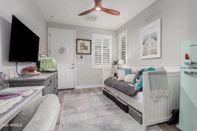 bedroom featuring ceiling fan and white fridge