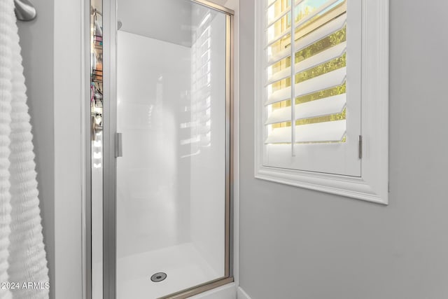 bathroom featuring a shower with door