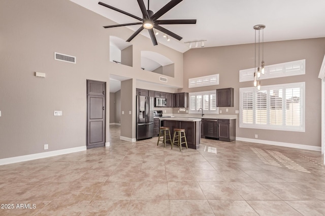 kitchen with visible vents, open floor plan, light countertops, a ceiling fan, and stainless steel appliances