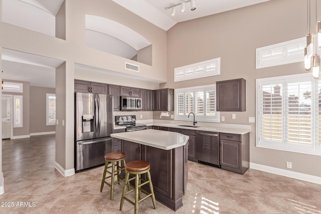 kitchen featuring visible vents, baseboards, a sink, light countertops, and appliances with stainless steel finishes