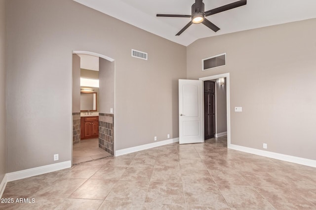 unfurnished bedroom with high vaulted ceiling, arched walkways, light tile patterned floors, and visible vents