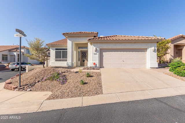 mediterranean / spanish home with stucco siding, concrete driveway, a garage, and a tile roof