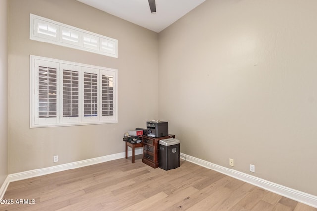 unfurnished office with baseboards, ceiling fan, and wood finished floors