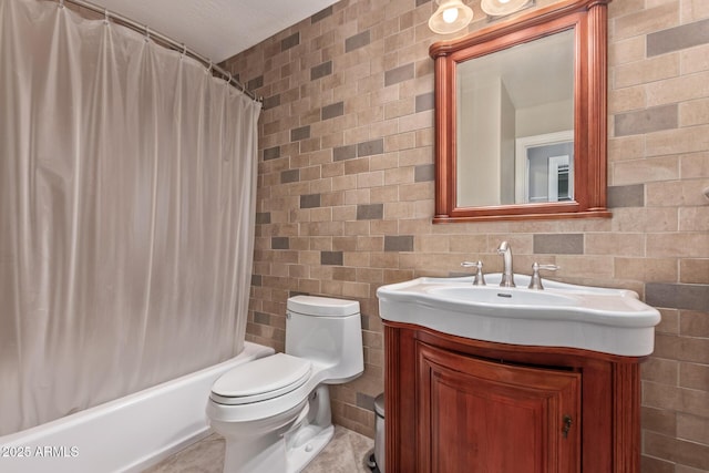 bathroom with toilet, vanity, shower / bath combo with shower curtain, and tile walls