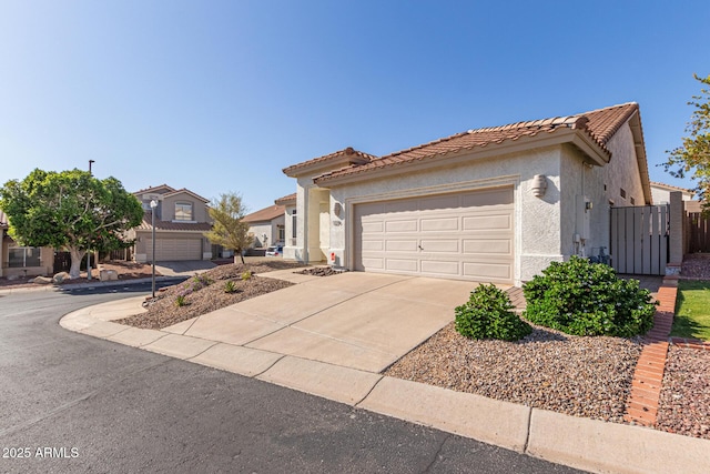 view of front facade featuring an attached garage, a tiled roof, concrete driveway, and stucco siding