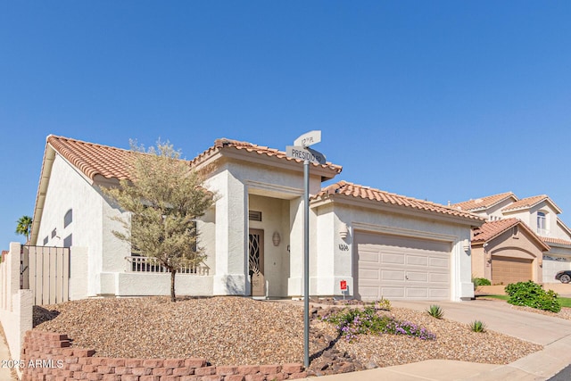 mediterranean / spanish house with concrete driveway, stucco siding, an attached garage, a tile roof, and fence