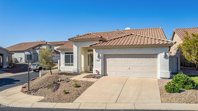 view of front of property with an attached garage, driveway, stucco siding, and a tile roof
